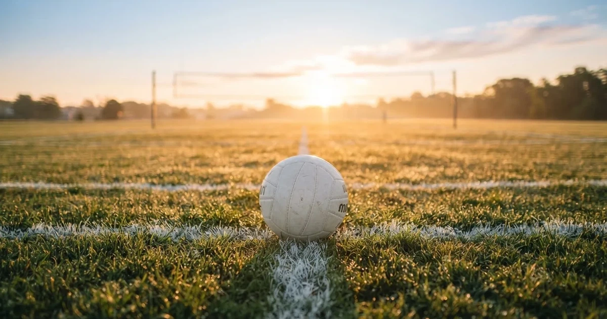 A ball on the centre spot of a grass pitch in morning light